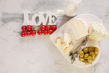 brie, camembert, gorganzola with olives and cherry tomatoes. Soft cheese with white and blue mold, olives and olive oil. Inscription love. Copy space, Top view, flat lay - 791132514