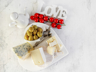 brie, camembert, gorganzola with olives and cherry tomatoes. Soft cheese with white and blue mold, olives and olive oil. Inscription love. - 791132531