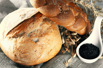 Round white bread. Close-up of homemade white bread with black salt in a white porcelain salt cellar. Close-up - 791133199