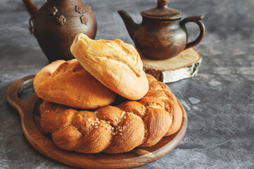 Kalach - traditional Lenten handmade bread on a village table close-up with assortment of handmade bread illuminated by natural light from a window