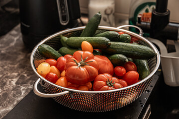 fresh healthy organic tomatoes and cucumbers in strainer