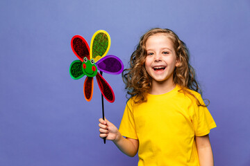 Photo of little cheerful girl happy positive smile hold paper toy windmill isolated over lilac color background. Summer vibes concept - obrazy, fototapety, plakaty