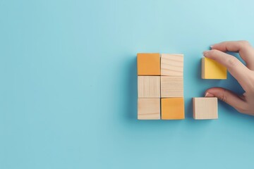 Closeup shot of a womans hand expertly arranging wooden blocks to symbolize the progression and success of a business concept, set against a serene blue background Plenty of empty space left for furth