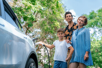 Family road trip vacation with electric vehicle, lovely family recharge EV car with green and clean energy. Natural and eco friendly car travel for sustainable environment. Perpetual - obrazy, fototapety, plakaty