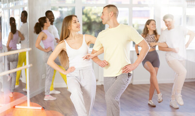 Group of middle-aged dancers rehearsing ballroom dances in dance studio