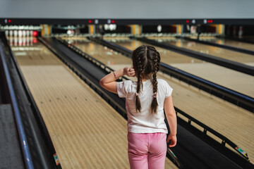 Child little girl playing bowling.