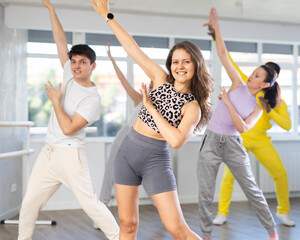 Active young woman practicing hip-hop dance in training hall during group dancing classes