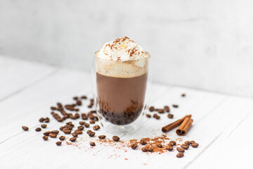 Cocoa drink with black coffee, whipped cream, chocolate on a light wooden table. Tasty coffee drink. 