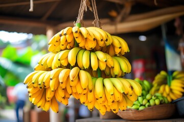 Closeup of a bunch of ripe bananas hanging from a market stall, with vibrant colors and fresh...