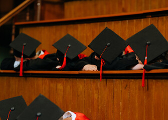 education, graduation, students - a group of students in bachelor gowns and caps in a lecture hall
