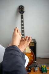 time to relax after played my electric guitar, close up of my feet - obrazy, fototapety, plakaty
