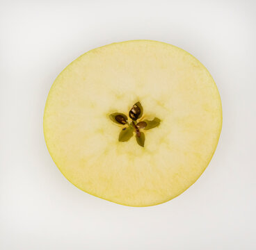 Close-up of a yellow apple cut in half.