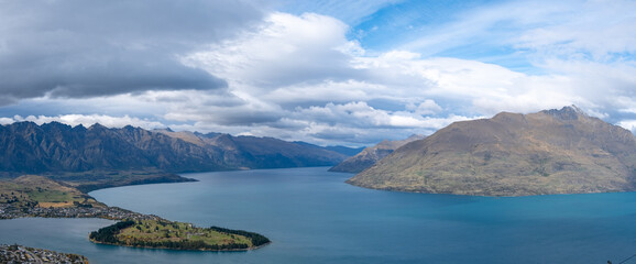 A vast panorama of New Zealand's stunning natural landscape of an inland lake and mountains. Lake Wakatipu, Queenstown. It is a popular tourist attraction and sightseeing travel destination.