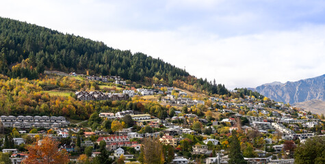 Panorama view of holiday houses and hotels on the rolling hills in Queenstown, New Zealand. A panoramic scenery of homes in the resort town.