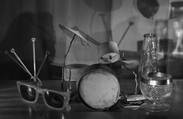 Grungy cardboard model of a grungy drum kit, vintage sunglasses and a drink.Music,performance,blues and rock music style, instruments concept,black and white - 791160550