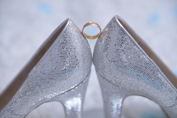 Wedding ring stand between twinkle women high heels shoes.