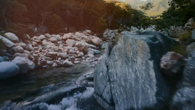 Beautiful aerial drone shot tracking smoothly along a winding river flowing through the scenic landscape of Baja California Sur
