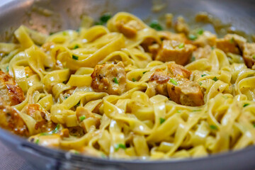 Tagliatelle in white sauce with chicken in selective focus