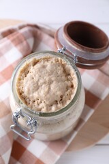 Sourdough starter in glass jar on table, above view