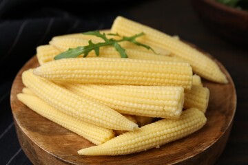 Tasty fresh yellow baby corns on wooden table, closeup