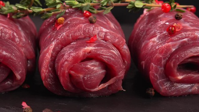 Lean uncooked veal swirls with thyme and himalayan peppercorns pepper in macro. Tender red meat. Promo for meat goods, clip for butcher's store, culinary event. Flank slice for ground beef