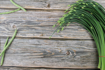 Garlic chives or Allium tuberosum on wooden table background. Fresh healthy organic green vegetable.