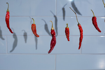 Chili pepper string before tiled kitchen backsplash. 