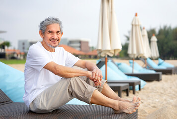 portrait mature male sitting on beach chair,feeling freedom,asian senior man having relaxation at...
