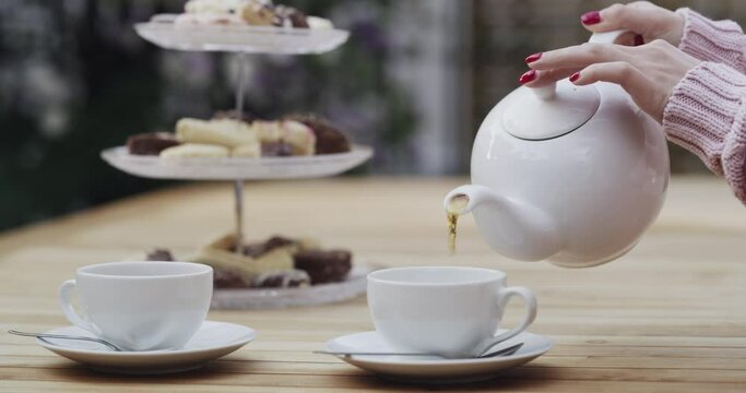 Hands, people and afternoon tea for relaxing in coffee shop, hot beverage and together on weekend. Friends, dessert and treats for bonding and rooibos for lunch, food and outdoor cafe or restaurant