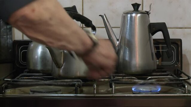 Elderly Man Heating Water on Gas Stove, Preparing Mate in His Home Kitchen, Argentina - Close Up