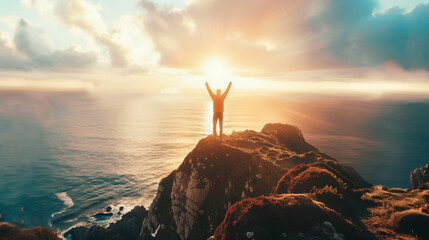 A man stands on a hill overlooking the ocean, with the sun shining brightly on him. He is holding his arms up in the air as if he is celebrating or expressing joy. Concept of freedom and happiness - obrazy, fototapety, plakaty