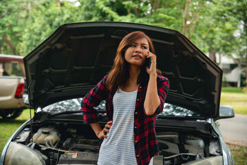 Women fix car call for help use phone calling insurance agent help fixing car problem breakdown....