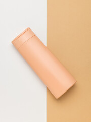 Top view of a shampoo bottle on a white and beige background.