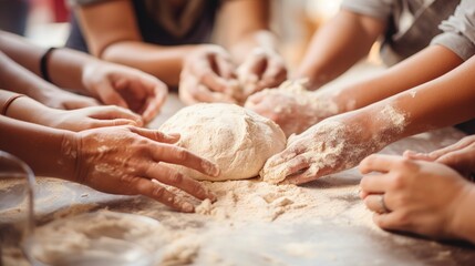 Fototapeta premium Close-up of a group of students kneading dough on floured surfaces during a bread-making workshop, focusing on the hands and dough. 