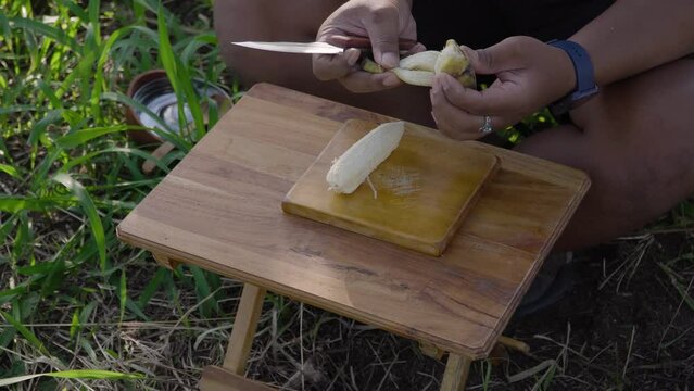 Bushcraft concept of cooking banana compote to break the fast in the forest with ASMR sounds. Close up of cooking activities in nature with minimal equipment in a calm and comfortable atmosphere