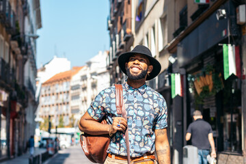 Stylish black man walking on the city street