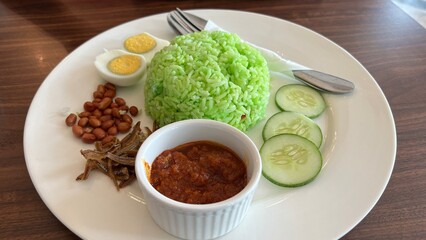 Nasi Lemak ,Nasi Pandan famous South East Asian dishe made with rice closeup with selective focus and blur - obrazy, fototapety, plakaty