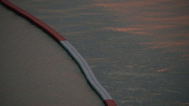 floating buoy barrier on sea, water wave in the evening