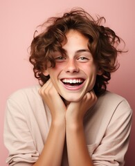 A young man with a pink shirt is smiling