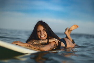 Candid lifestyle portrait of a woman on a surfboard
