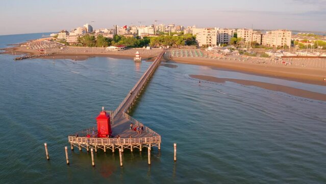 4k drone flight moving to the side footage (Ultra High Definition) of Lignano Sabbiadoro port. Adorable outdoor scene of Adriatic coast of Italy with red lighthous. Stunning Mediterranean seascape.
