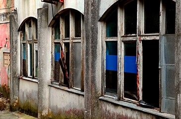 Arched windows with wooden frames of an old abandoned house