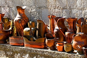 Vintage copperware on the sidewalk outside a craftsman's workshop