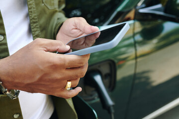 Closeup image of ev owner checking battery level via app