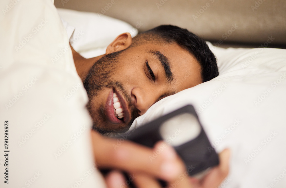 Poster man, bed and tired or phone for internet in home, pillow and network to scroll on social media. male