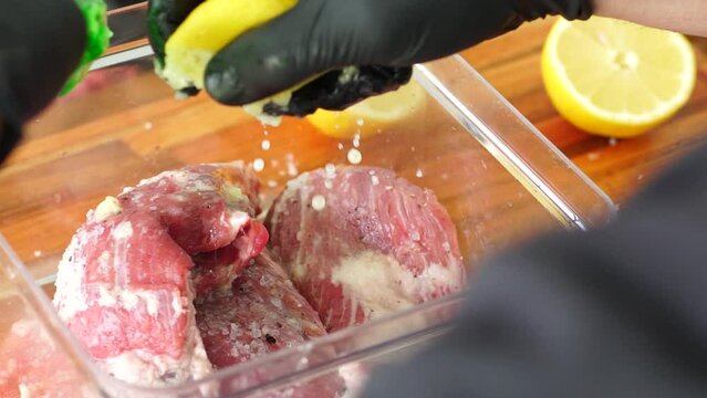 Squeezing Lemon Seasoning Raw Meat for Argentine Bondiola, slow-motion close-up
