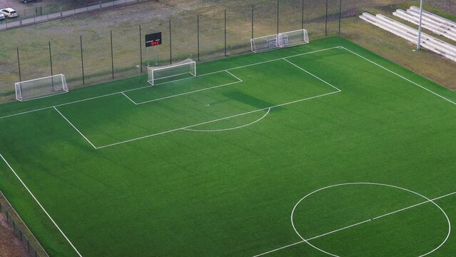 Aerial drone pan up from grass empty football soccer pitch