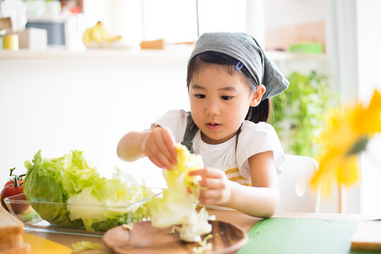 エプロン姿でサンドイッチを作っている女の子