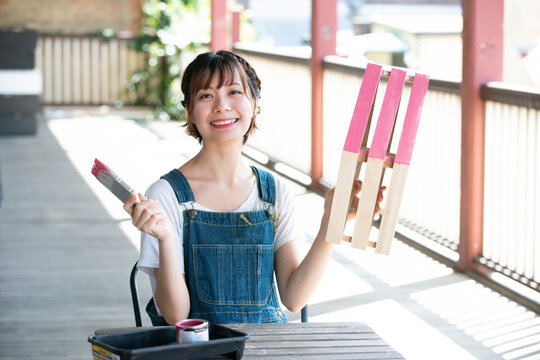 刷毛と手作りの箱を持って笑っている女性