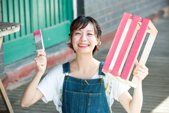 刷毛と手作りの箱を持って笑っている女性